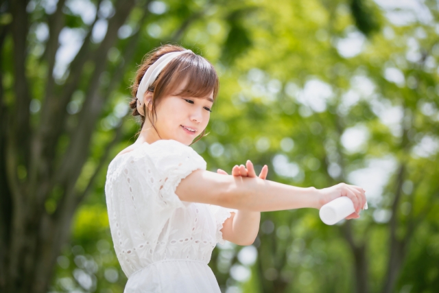 蚊の対策:虫よけスプレーをする白い服を着た女性
