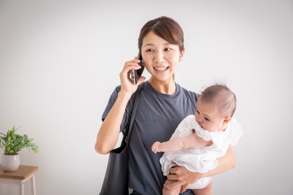 花の定期便:赤ちゃんを抱いてスマホで話をしている忙しそうな女性