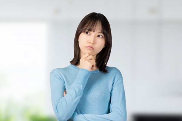 花の定期便:青いトップスを来た考える女性